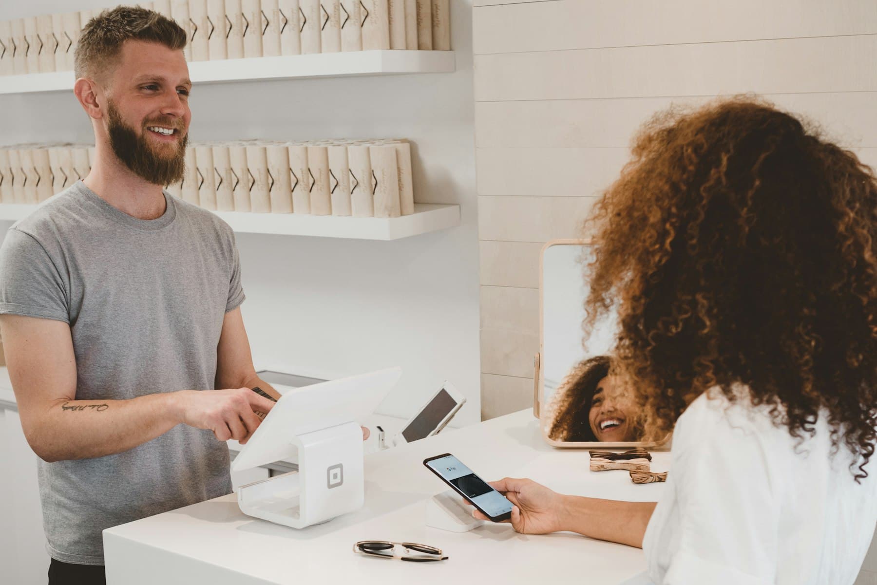 A shop owner at a counter helping a customer